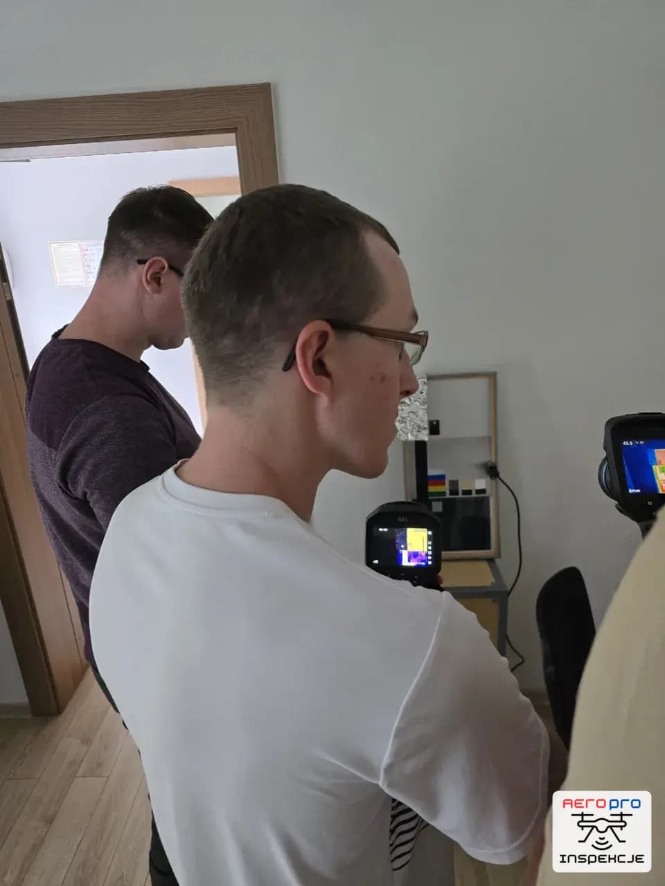 Uczestnicy szkolenia wykonujący pomiar termowizyjny stropu kamerą ręczną